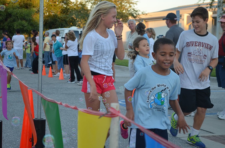 Runners make it to the finish line after completing the 1 mile Fun Run.