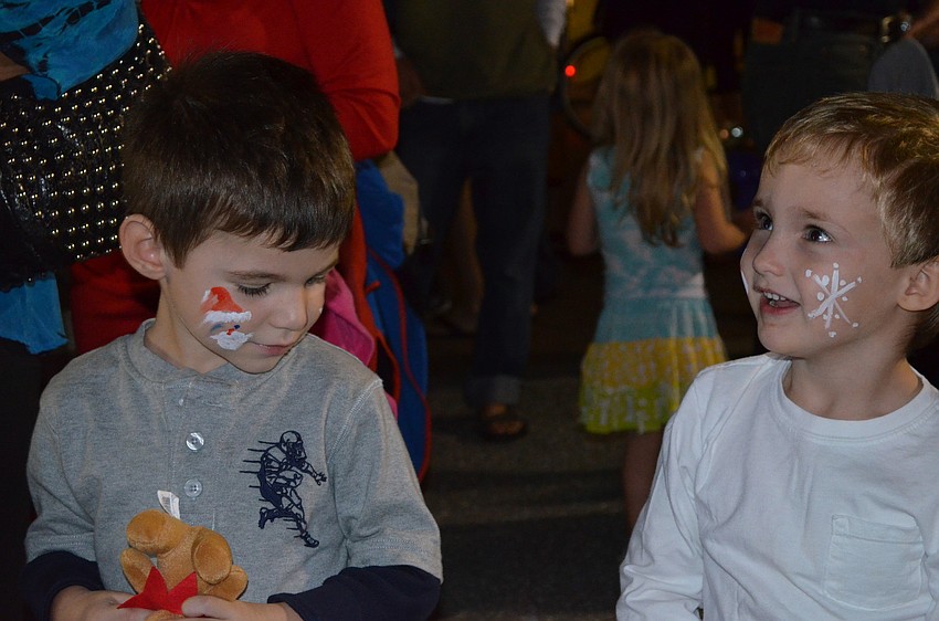 Andre Hersom and Henry Gilbertson wait for a balloon animal by Sunshine the Clown.