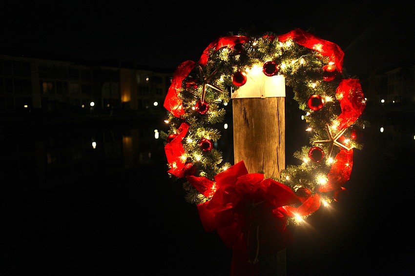 A festive wreath hangs from a dock.