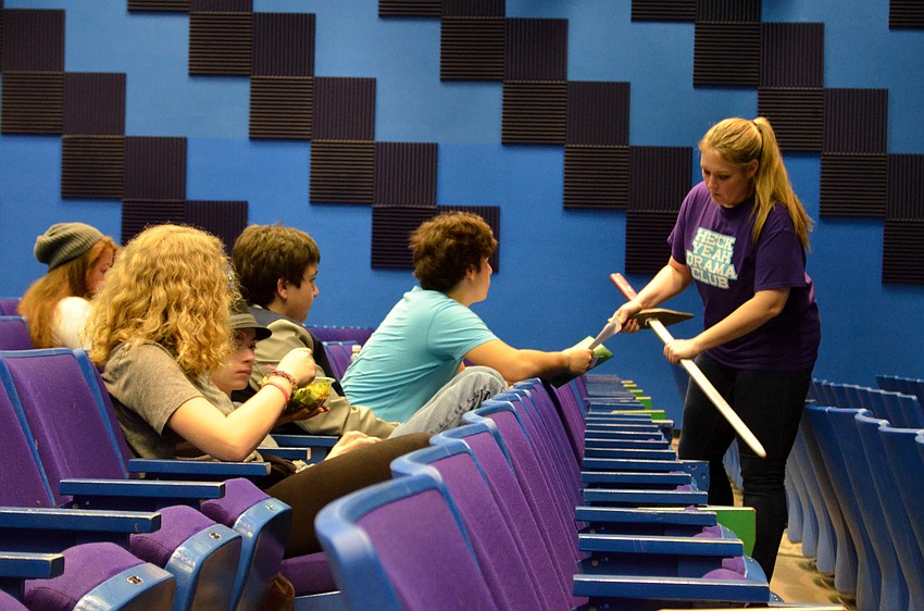Robin Melton works with Tristan Laham to get his sword the right length while other students watch