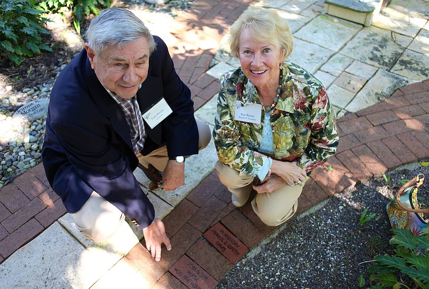 Tom and Sue Reese kneel next to an engraved brick their children gave to them as a Christmas gift.