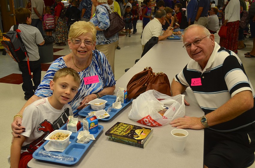 Nine-year-old Seth Gross shows his grandparents â€” Audrey and Larry Gross â€” his new book.