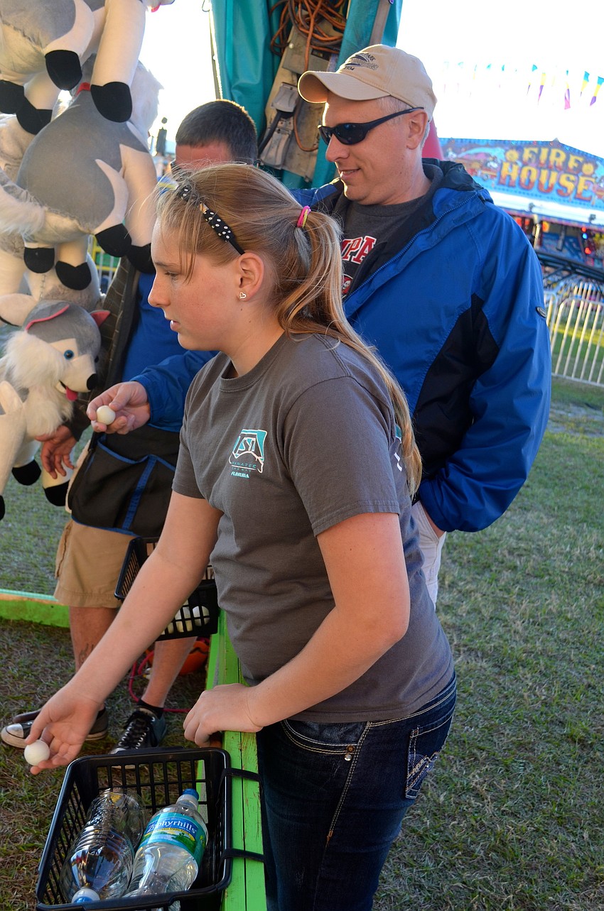 Hayley Lotozynski, 12, and her father, Harry, toss ping-pong balls for chances to win a rabbit.