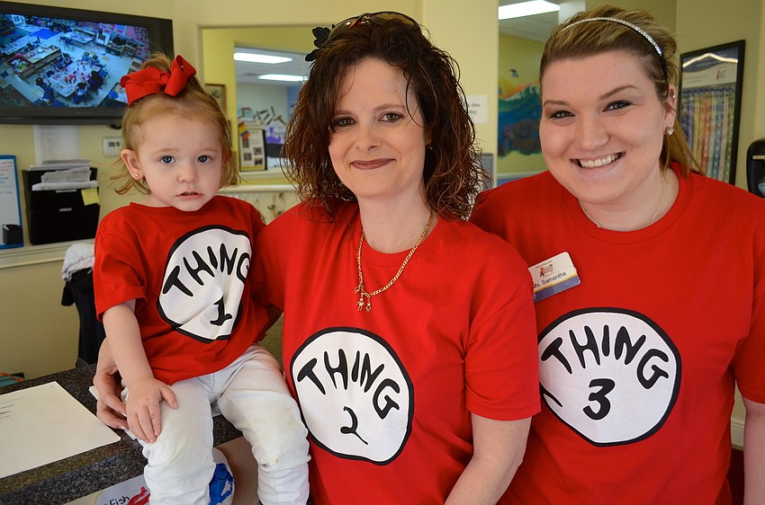 Josie Pouso, 2, and her mother, Tina, pose next to Thing Three, Samantha Raszka.