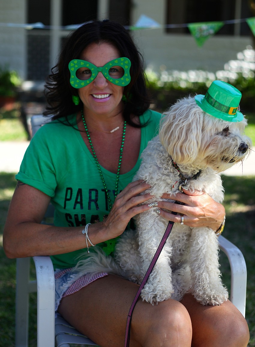 Jodi Tharou and her dog, Tags, enjoy the parade from the sidewalk.