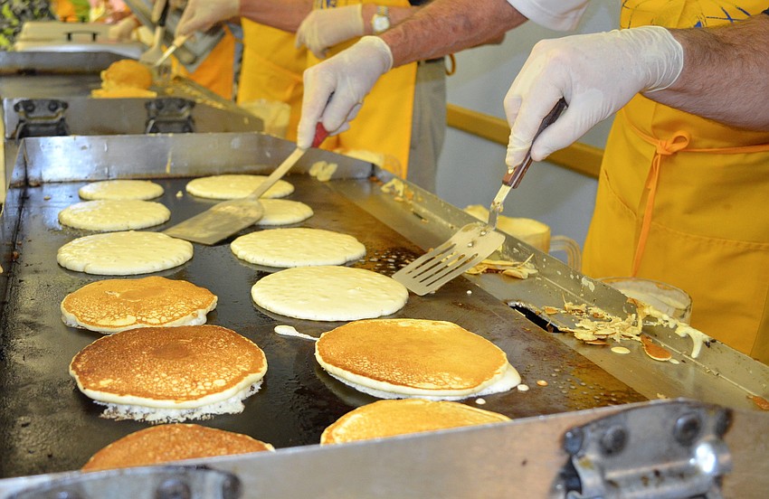 Kiwanis members flip pancakes.