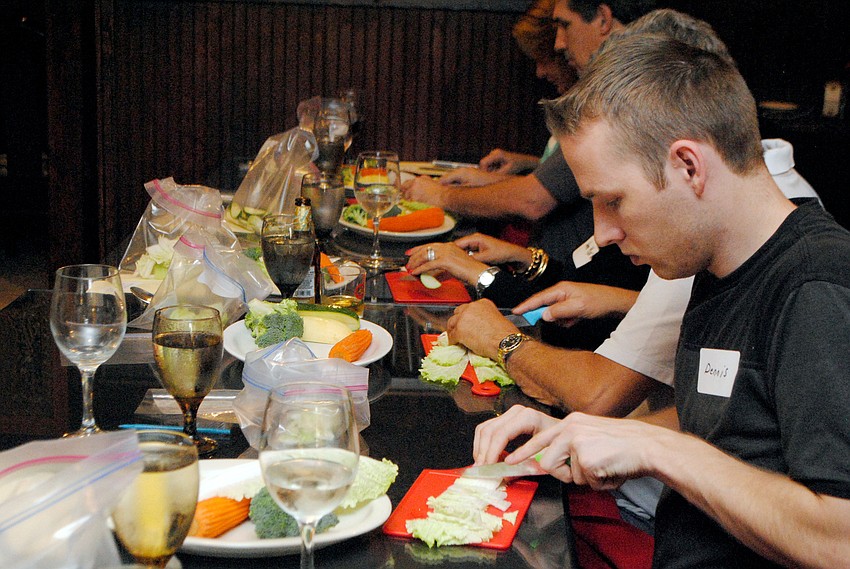 Students in Taste of Asiaâ€™s cooking class slice and dice vegetables.