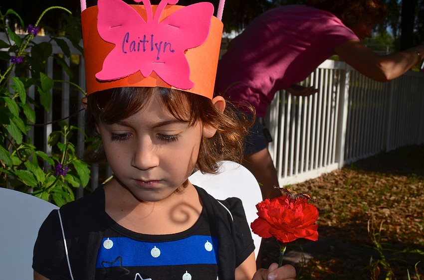 Caitlyn Drizos watches another classmate release their butterfly.