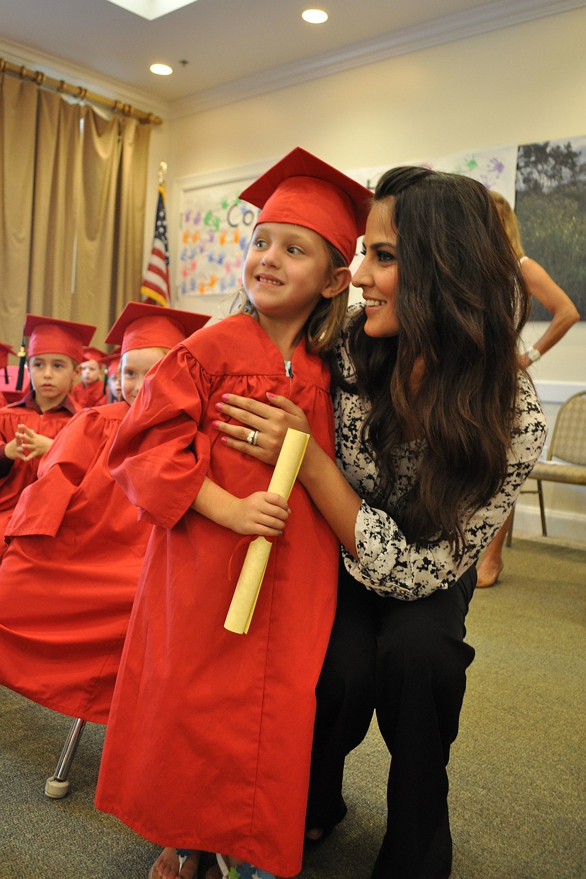 Kenzie Carlino receives her diploma from teacher Shagolfa Hassanzadeh