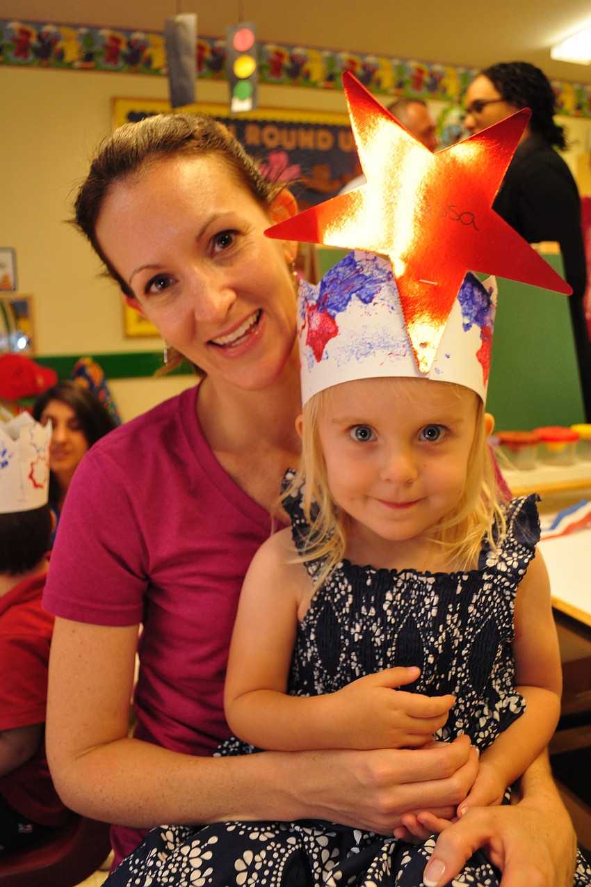 Stephanie Call gives her daughter Alyssa, 2, a hug, as she enjoys a cookie after the parade.
