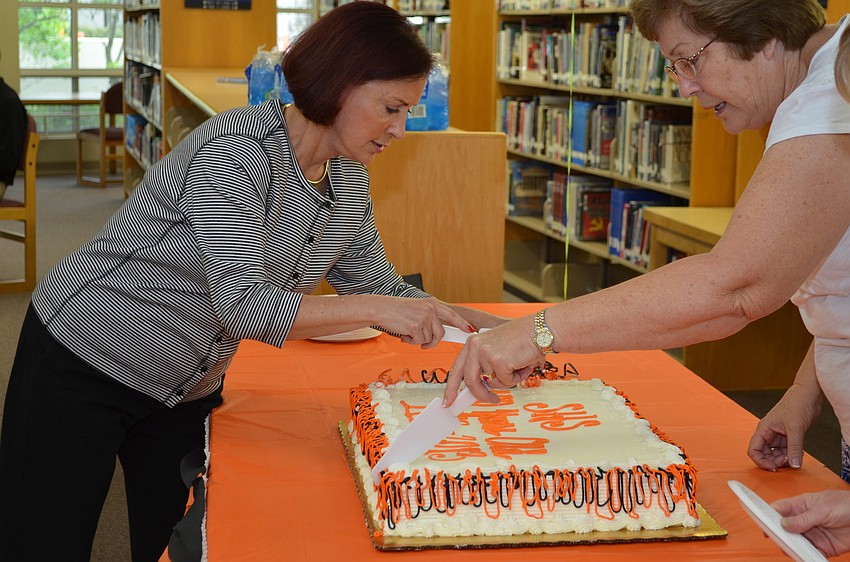Star Conti and Maolyn Remillard begin cutting the cake.
