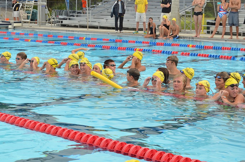 The Sarasota Sharks swim team wades in the water and watches as Ryan Lochte swims a lap.