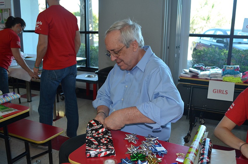 Dave Kritzmacher helps wrap gifts