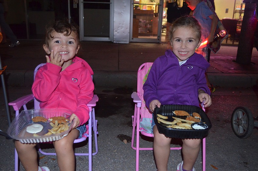 Isabella and Sophia Pacheco made sure not to miss the parade by eating dinner outside