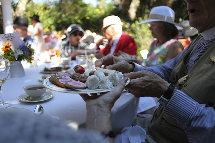Sue Reese passes a plate of sweets to the Rev. Vincent Carroll.