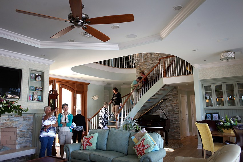 Guests tour the Whiteâ€™s great room and discuss the view of the water.