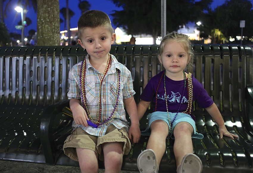 Brennan Duffy, 4, and Kayla Duffy, 2, enjoy the colorful beads and kazoos they collected during the parade.