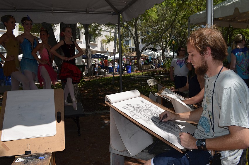 John Treanor draws ballerinas at Ringling College of Art and Design's booth.