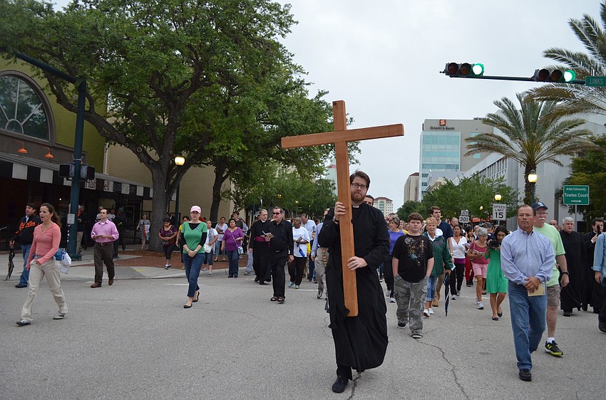 Rev. David Bumsted carries the cross.