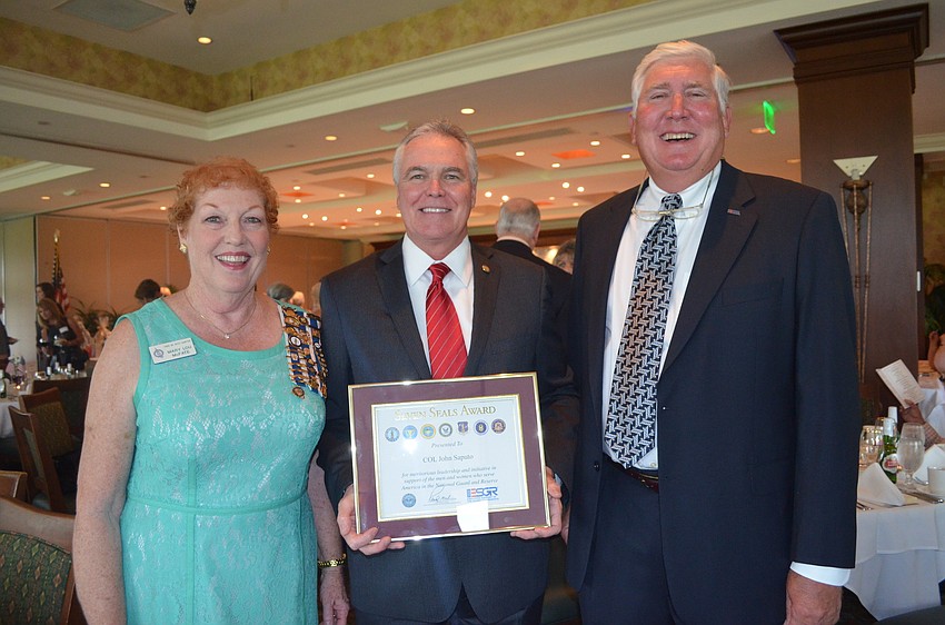 Mary Lou McFate with Representative Ron Reagan and Dave McCormick presented Saputo with the Seven Seals Award.