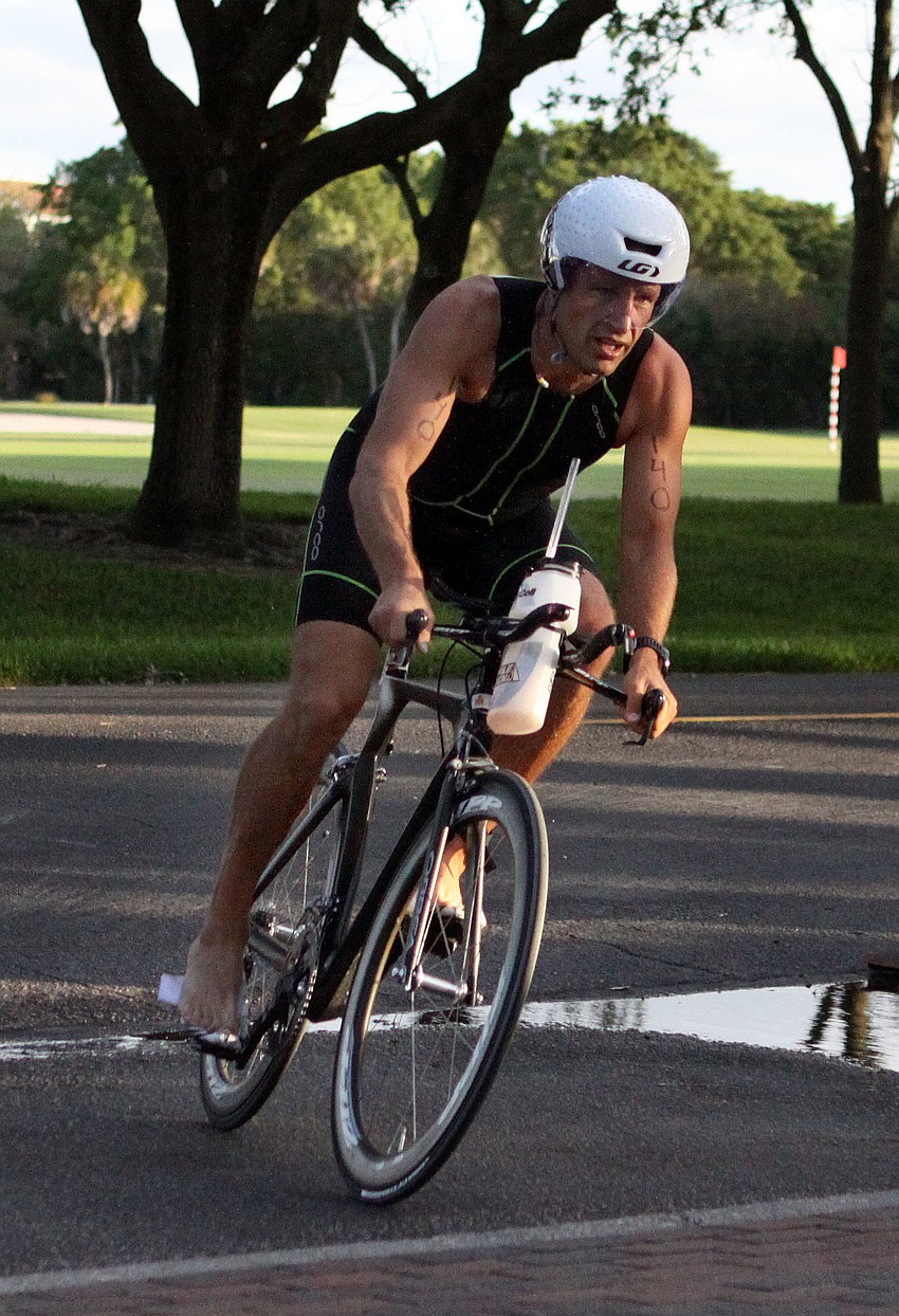 Derek McGarvey, No. 140, makes his way to the dismount area after completing the biking portion of the sprint triathlon.