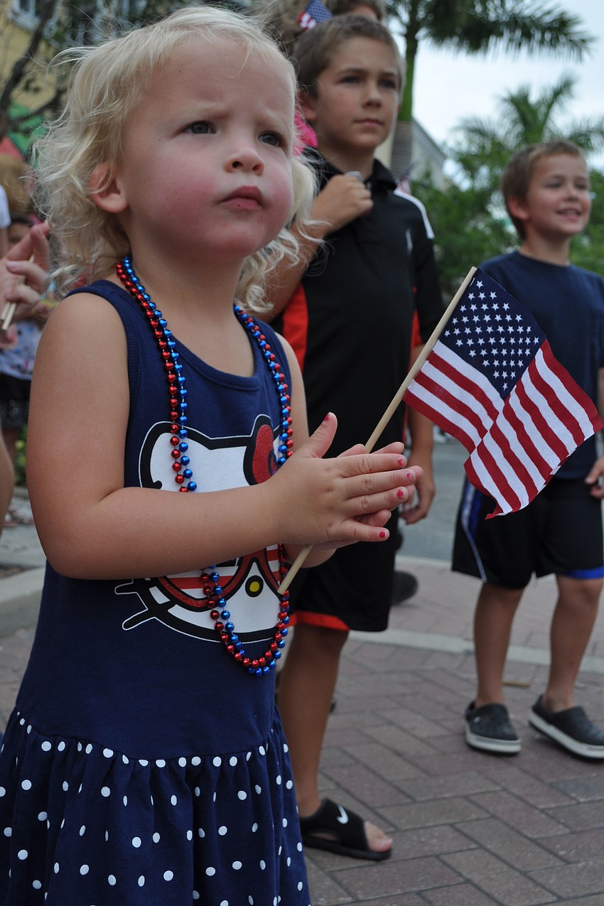 Hayden Bowles, 3, claps as floats pass by on the street.