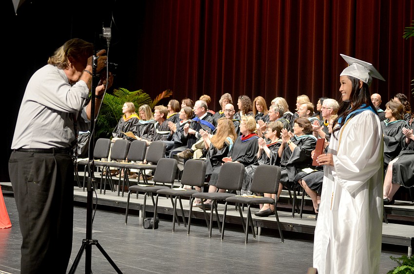 Students pose with their diplomas for a photograph.