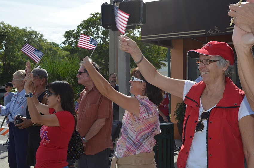 Lourdes Alcox, Susan Geeslin and Barbara Branning wave and cheer on the veterans