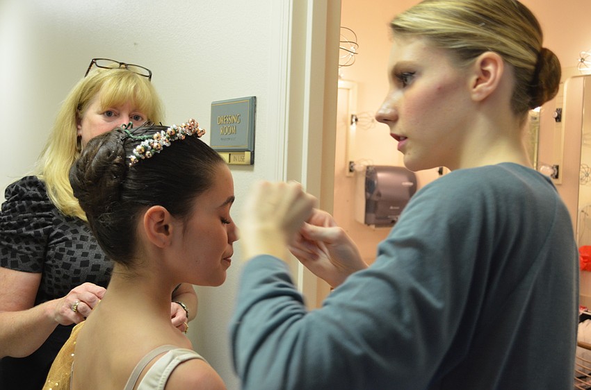 Rachel DeHart (right) adjusts Jadyen Capellaâ€™s (left) bun