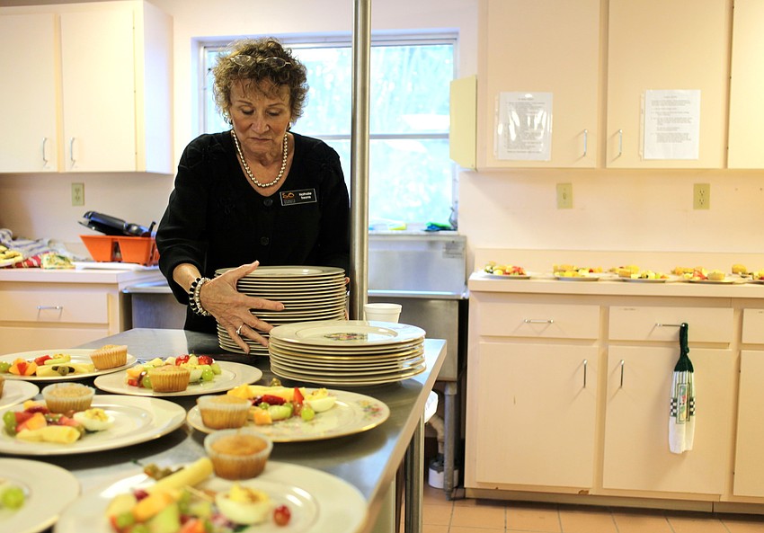 Nathalie Treonis helps prepare plates for the Welcome Back Brunch.