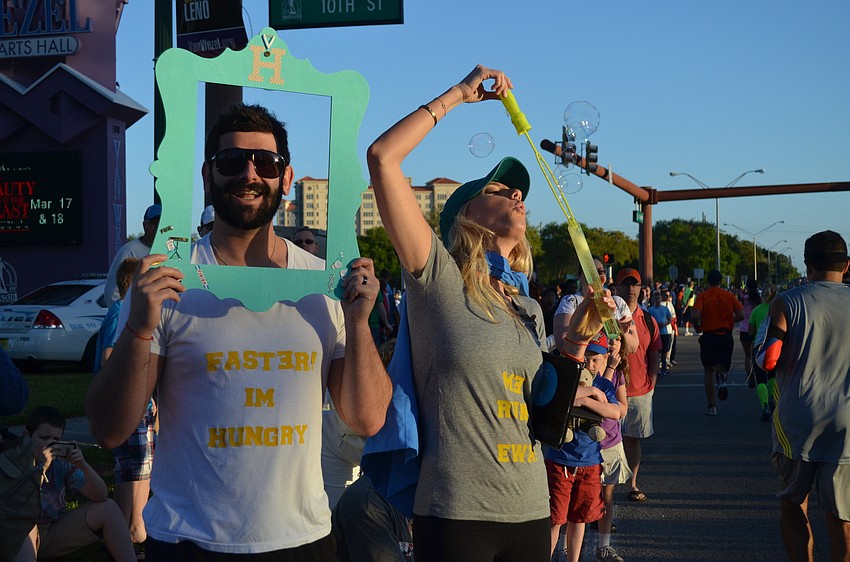 Darren and Carly Odesnik cheer on Darren's parents with bubbles and humorous shirts.