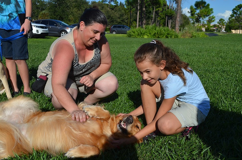 Tricia Egan and her daughter Katelyn pet their dog, Maggie.