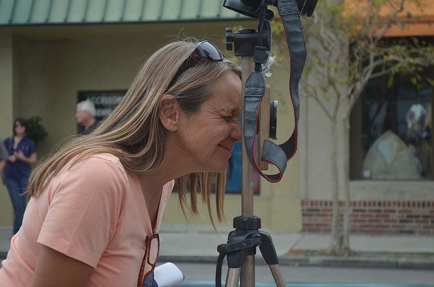 Pauline St. Martin looks through a lens for a 3D effect