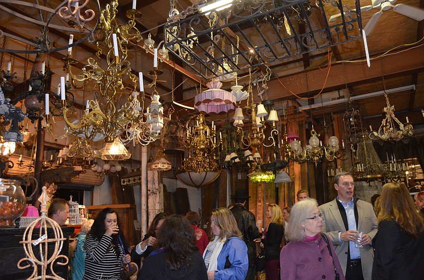 Attendees mingle underneath a collection of salvaged chandeliers.