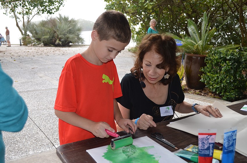 Klae Hochstetler learns to make leaf prints with Jo-Ann Migilore Campisi.