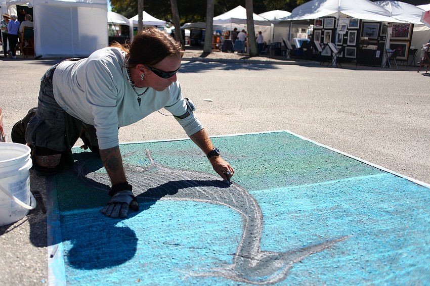 Stig Lindow, a multimedia artist, works on his chalk painting on the outskirts of the festival.