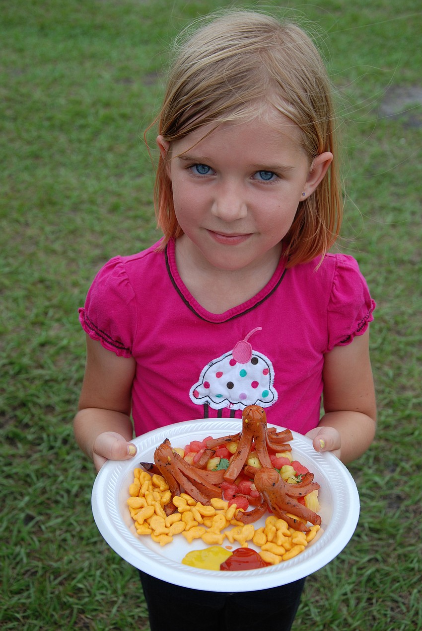 Lorelai Lis, 6, shows off her octopus-shaped hotdogs before submitting them to the judges.