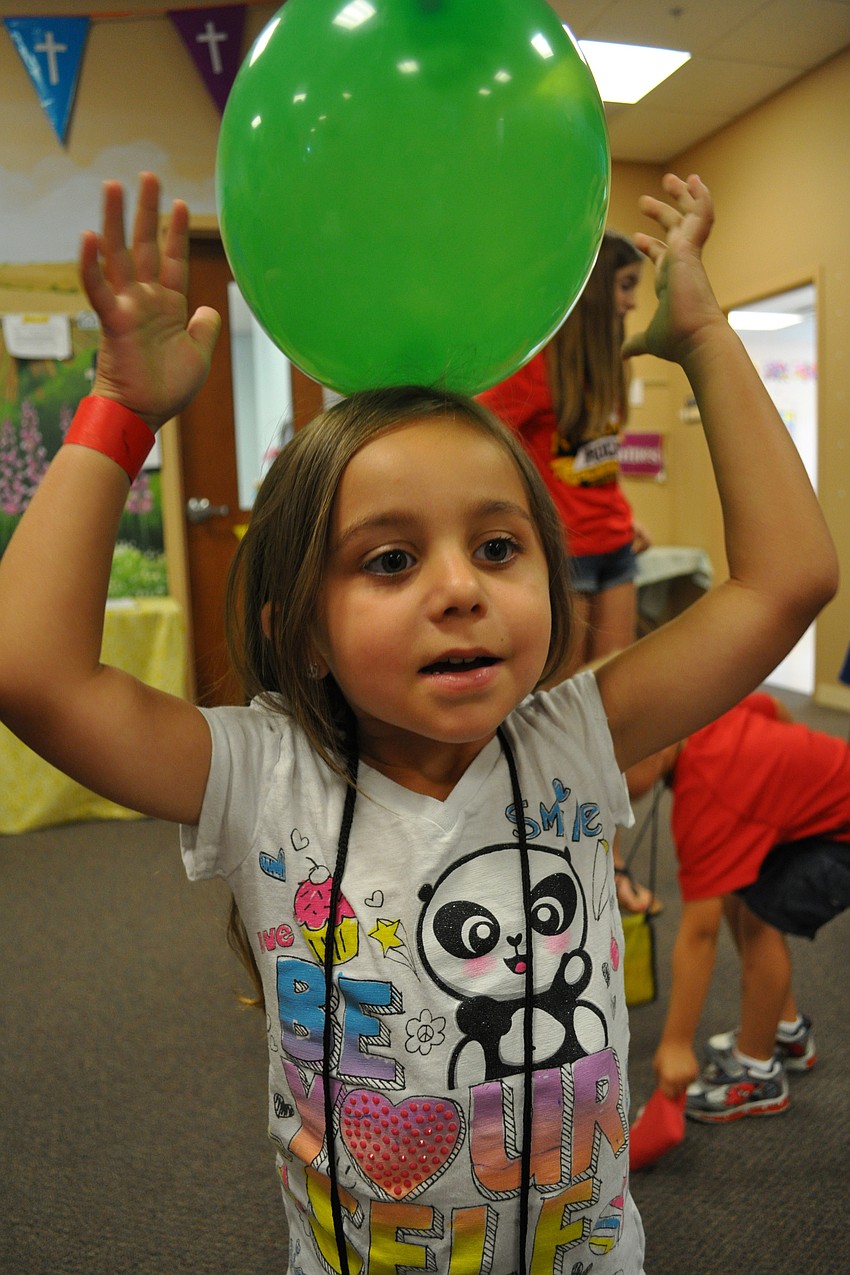 Julia Griffin, 4, tries to balance a balloon on her head.