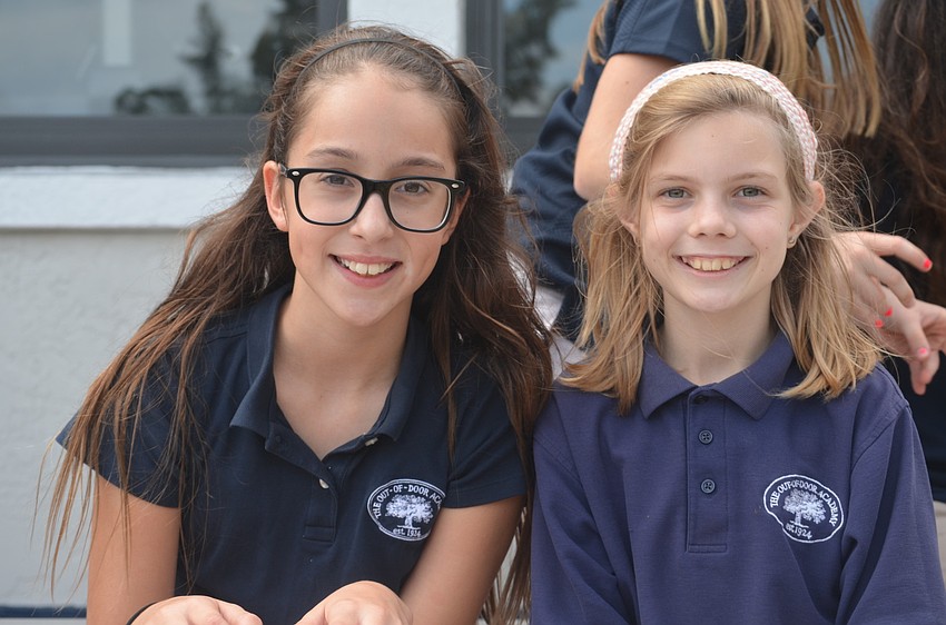 Sam A. and Chelsea B. sit on the bleachers