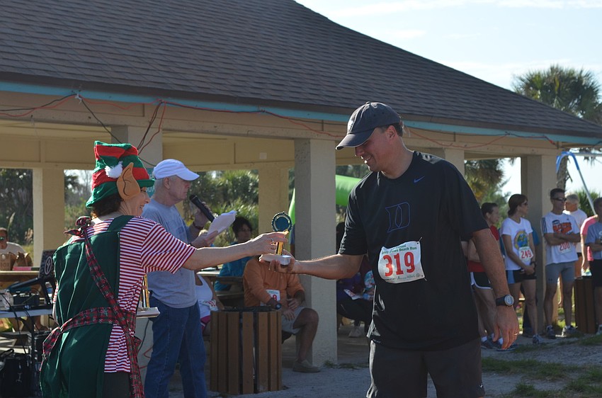 Scott Collins receives his trophy for third place in his age group.