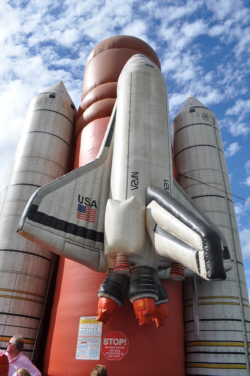 Children enjoy a rocket-themed inflatable slide.