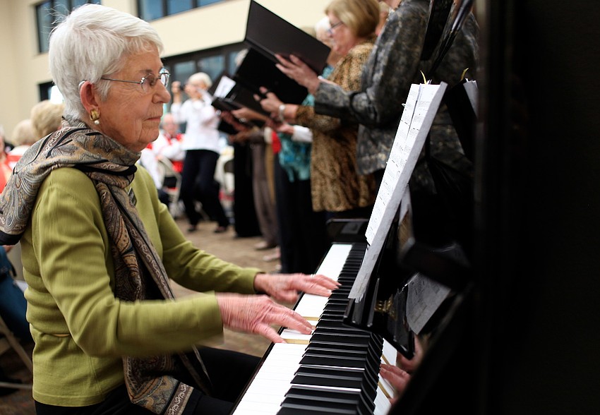 Kathleen Semisch plays the piano as the choir sings.