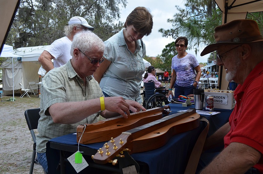 Ray Spyker teaches Robert Weyrick how to play the mountain dulcimer.