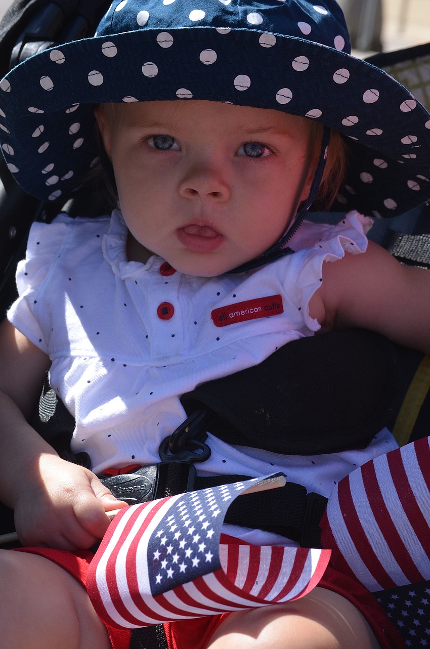 Fifteen-month-old Harper Hunter waved her flag from the sidelines at the parade.