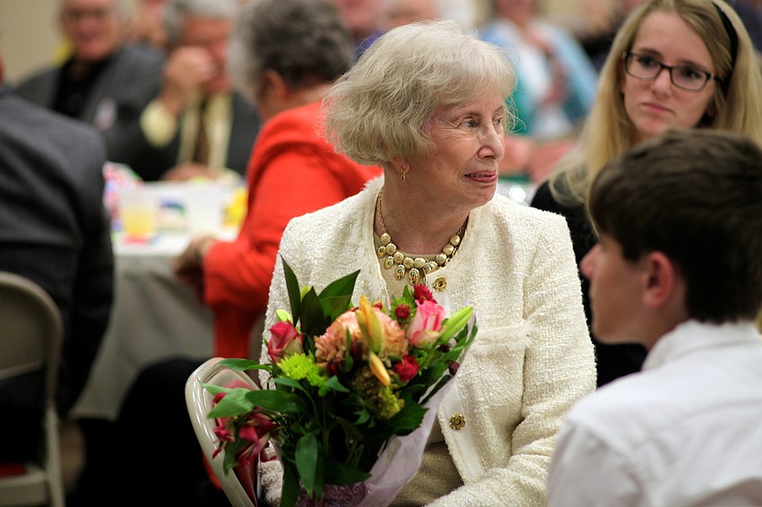 Ginny Porter smiles after a barbershop quartet serenaded her and offered a bouquet of flowers from the congregation.