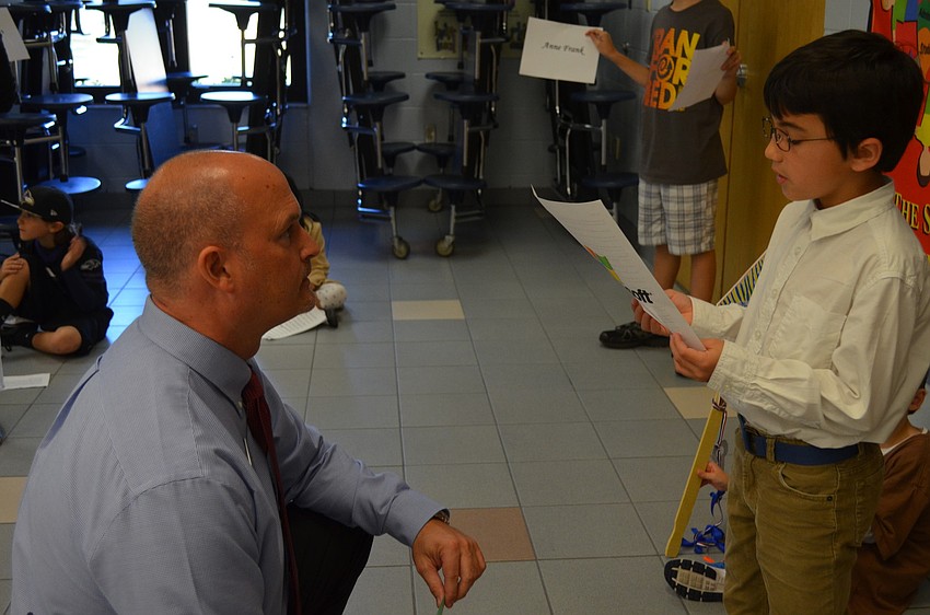 Principal Chris Renouf listens to Noah Weeks as Bill Gates.