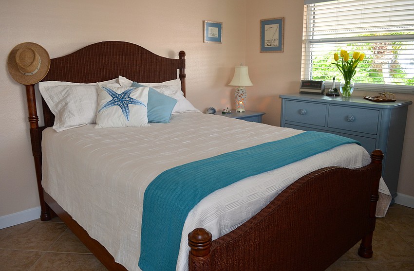 The master bedroom features calming colors and a beach theme.