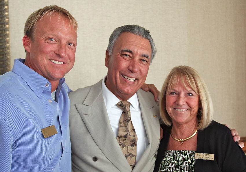 President Eric Seace and Executive Director Diana Corrigan pose with Andrew Vac, Director of Membership, after giving him a bottle of wine as a token of their appreciation for all his hard work.