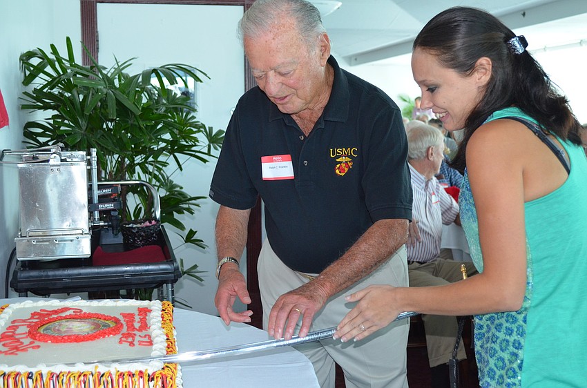 Tâ€™ann Mikolajcik cuts the cake. Mikolajcik represents all the families of the Marine Corps.