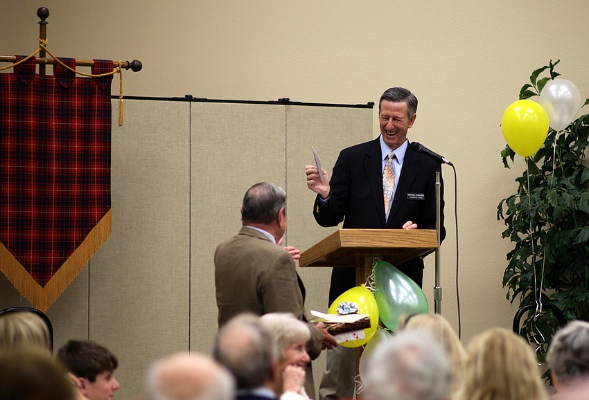 Michael Chester gives the Rev. Bruce Porter one of many parting gifts from the church.